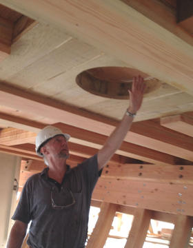 Standing below the topmost deck of the partially build Matthew Turner, Construction volunteer Ian Sidely shows the hole where the main mast will be inserted  later in the project.